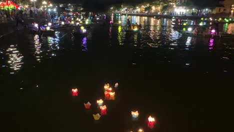 Hoi-An-Vietnam-Laternen-Schweben-Im-Vordergrund-Mit-Laternenbooten-Entlang-Des-Flusses-Thu-Bon-Mit-Dem-An-Hoi-Nachtmarkt-Im-Hintergrund