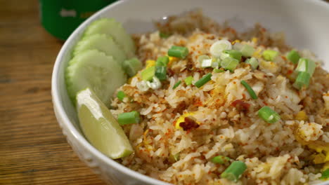 Table-top-shot-bowl-of-crab-fried-rice-plated-with-sliced-cucumbers-and-green-onions,-slider-close-up-4K