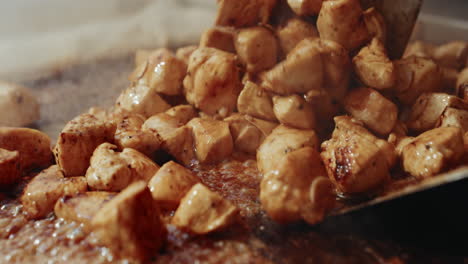 Flipping-sizzling-chicken-chunks-in-soy-sauce-on-festival-grill