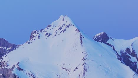Genießen-Sie-Den-Panoramablick-Auf-Den-Sonnenaufgang-über-Der-Silhouette-Einer-Schneebedeckten-Bergkette-Durch-Diese-Faszinierende-Drohnenaufnahme