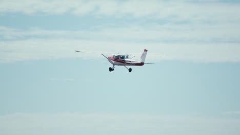 Small-private-airplane-Cessna-152-taking-off-from-small-airfield-into-clear-blue-skies