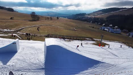Skiing-athletes-jump-on-ramp-and-do-backflip,-Dolni-Morava-winter-event