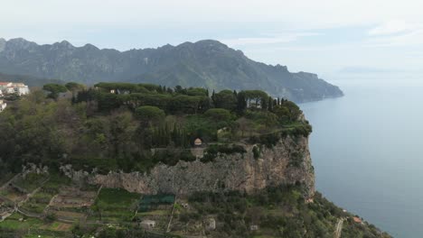 The-terrace-of-infinity-in-ravello-with-lush-greenery-and-sea-backdrop,-cloudy-day,-aerial-view