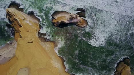 Top-Down-Panning-View-Overhead-La-Catedral-Rock-with-Pacific-Ocean-Waves,-Peru,-South-America