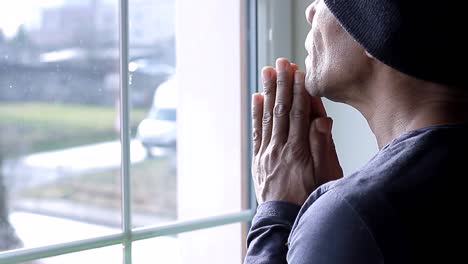 praying-to-god-with-hands-together-looking-out-of-the-window-with-people-stock-video-stock-footage