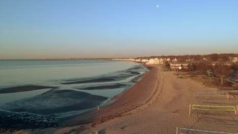 Aerial-drone-view-of-a-person-walking-on-a-beach-at-low-tide