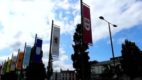 Familienwappenflaggen-In-Galway,-Während-Die-Menschen-Am-Eyre-Square-Entlang-Gehen