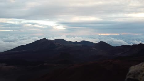 Time-lapse-dawn-with-the-sun,-crater-and-puffy-cloud-cover-at-the-top-of-volcano-summit-crater-at-Haleakala-National-Park-which-is-a-massive-shield-volcano,Maui,Hawaii,USA