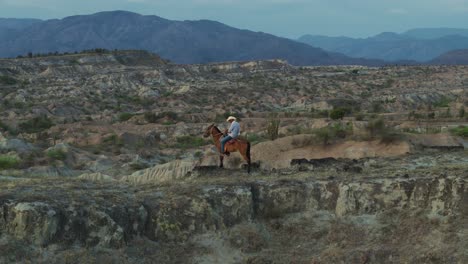 Vaquero-A-Caballo-En-El-Paisaje-De-La-Cresta-Del-Desierto-De-Tatacoa,-Revelación-Aérea-Cinematográfica