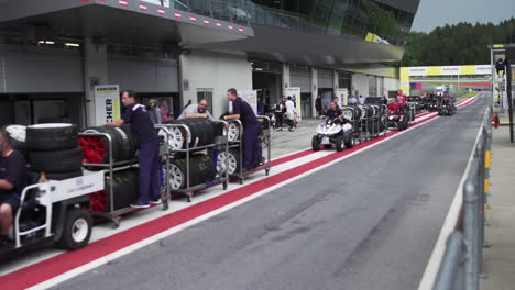 Pit-lane-crew-driving-before-race-starts,-preparing