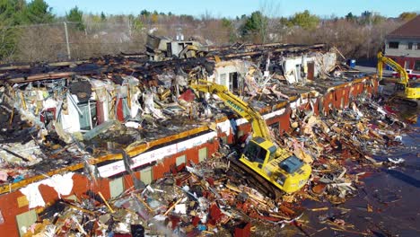 Backhoe-Demolishing-Commercial-Building-Damaged-By-Fire-In-Blainville,-Quebec,-Canada