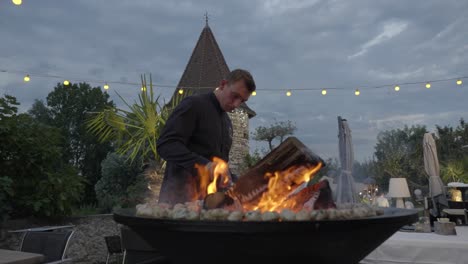 Slow-motion-shot-of-an-employee-attending-to-keep-the-fire-burning-at-a-wedding