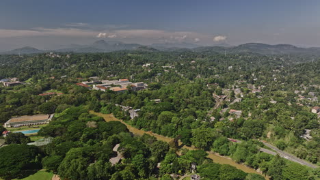Peradeniya-Sri-Lanka-Aerial-v7-high-altitude-drone-flyover-University-campus-capturing-the-landscape-views-of-Mahaweli-river,-A1-road-and-hillside-Kandy-suburbs---Shot-with-Mavic-3-Cine---April-2023