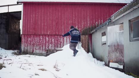 Mann-Verlässt-Im-Winter-Ein-Bauernhaus,-Um-Müll-Ins-Freie-Zu-Werfen