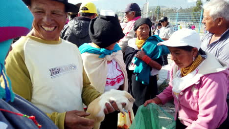 Local-Ecuadorians-trading-goods-at-Otavalo-market,-bright-daylight,-vibrant-cultural-interaction