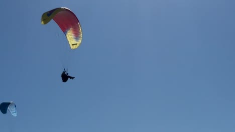 Para-gliders-fly-across-each-other-on-a-beautiful-day-at-Torrey-Pines-Gliderport-in-La-Jolla,-California