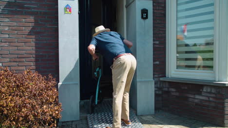 Mobility-impaired-old-man-using-rollator-and-metal-ramp-struggling-to-enter-home