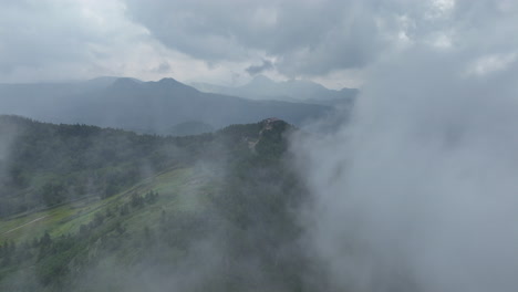 Drone-flying-through-clouds-in-the-Shiga-Highlands,-gloomy,-summer-day-in-Japan