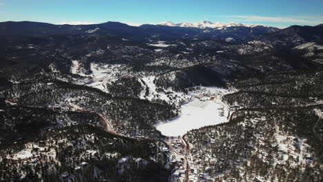 Evergreen-Colorado-aerial-drone-downtown-high-altitude-incredible-scenic-view-of-Mount-Evans-Bluesky-three-sisters-lake-house-golf-course-high-school-winter-sunny-morning-Denver-open-space-backward