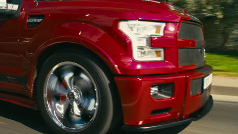 Tracking-shot-of-front-tires-of-a-2018Cherry-Red-Ford-Shelby-Super-snake-driving-down-a-highway-in-Estonia