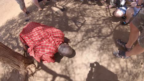 African-Maasai-man-makes-bonfire,-shows-tourists-how-to-start-fire,-Kenya