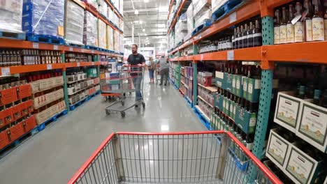 POV---Langsames-Schieben-Einer-Karte-An-Flaschen-Mit-Schnaps-In-Einem-Lokalen-Costco-Vorbei