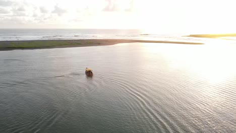 the-aerial-view,-the-boats-sailing-in-the-lagoon-at-sunset-looks-very-beautiful