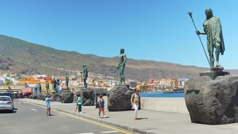 Tourists-taking-photos-of-Guanche-king-statues,-located-on-Plaza-de-la-Patrona-in-Candelaria,-Tenerife,-Canary-Islands