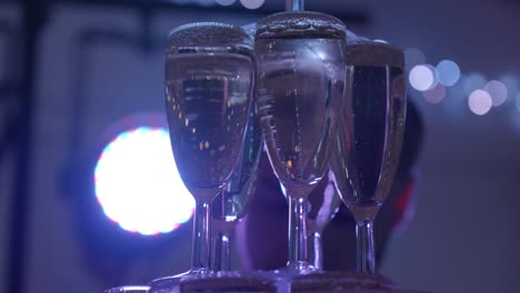 Tower-of-glasses,-waiter-fills-them-with-champagne-at-wedding-party