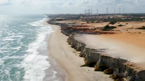 Vista-Aérea-De-Los-Acantilados-De-Morro-Branco-Y-La-Energía-Eólica,-Ceará,-Brasil.