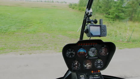 Robinson-R44-instrument-panel-and-control-joystick-during-take-off-and-flight-over-a-field