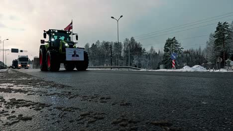 A-caravan-of-tractors-and-trucks-on-the-asphalt-road,-farmers-protest-against-government-decisions