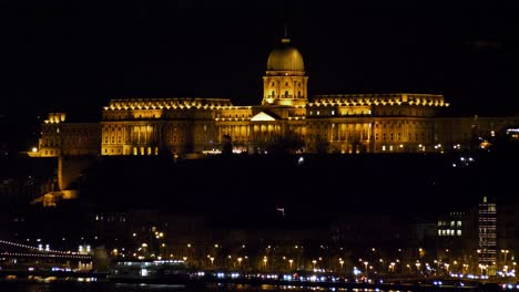 Blick-Auf-Die-Innenstadt-Von-Budapest-Mit-Beleuchteter-Budaer-Burg-Und-Donau-Bei-Nacht,-Gotische-Architektur,-Lichtreflexionen,-Weitwinkelaufnahme-Aus-Der-Ferne