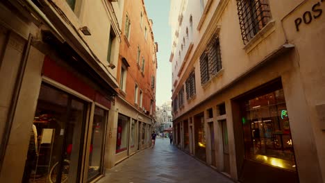 Camera-moving-forward-in-a-"calle"-typical-street-of-Venice,-Italy