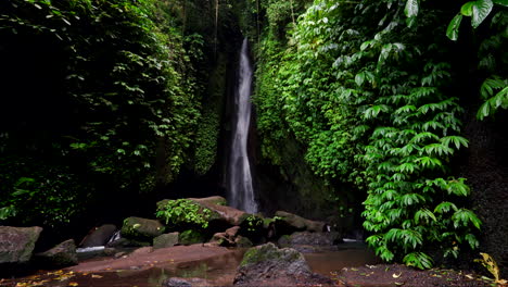 Slomo-of-tall-narrow-Leke-Leke-waterfall-surrounded-by-cliffs-and-vegetation