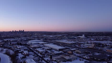 Airplane-flying-over-winter-Calgary-Downtown-at-sunset