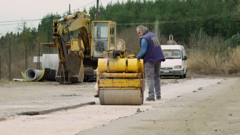 Middle-age-worker-male-Hand-Operated-Mini-Road-Roller-Compactor