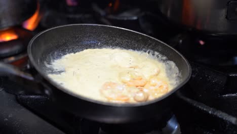 Cooking-shrimp-with-sour-cream-in-a-cooking-pan-in-slow-motion