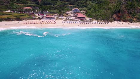 Petani-beach-in-kefalonia,-greece-with-turquoise-waters-and-sunbathers,-aerial-view