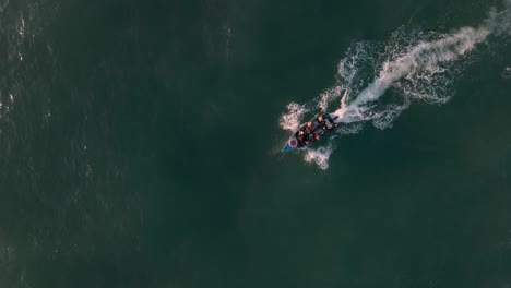 Top-down-shot-of-a-small-fishing-boat-returning-back-to-the-Mozambique-shore
