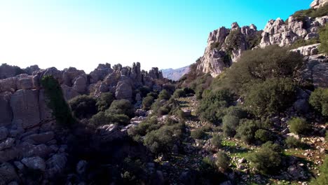 Aerial-backward-dolly-in-between-the-rocks-on-the-nature-reserve-at-El-Torcal-de-Antequera,-Malaga,-Andalusia,-Spain