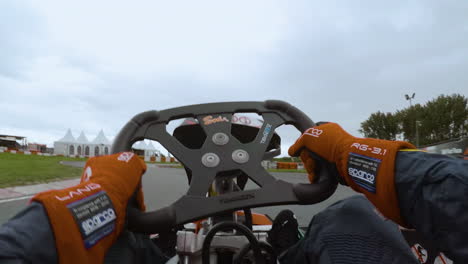 Onboard-chest-view-of-kart-driver-racing-on-outdoor-Almere-circuit