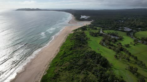 Paisaje-Tranquilo-De-La-Playa-Y-El-Arroyo-De-Pertenencia,-Byron-Bay,-Nsw,-Australia---Disparo-Aéreo-De-Drones