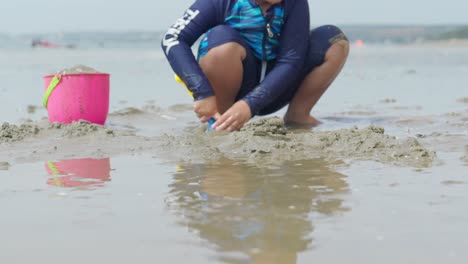 Two-Asian-children-playing-on-the-sand-at-a-beautiful-beach