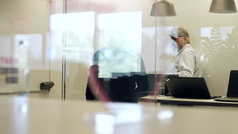 Business-meeting-in-glass-cubicle,-office-workers-discussing-targets,-corporate