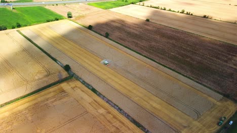 Slow-Motion-Aerial-View-Of-Combine-Harvester-Working-On-A-Field