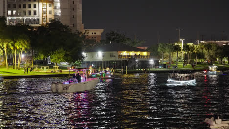 People-Riding-Colorful-Boats-During-Lighted-Boat-Parade-In-Tampa,-Florida-USA