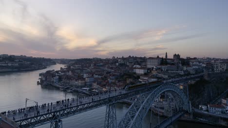 Atemberaubender-Zeitraffer-Von-Porto-Von-Tag-Zu-Nacht,-Mit-Der-Berühmten-Brücke-Ponte-Luis-I,-Der-Stadtlandschaft,-Dem-Lebhaften-Sonnenuntergang-Und-Den-Lichtern-Der-Stadt