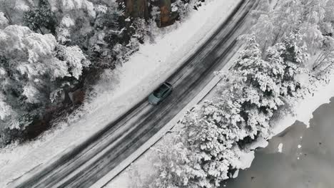 Imágenes-De-Drones-De-Un-Automóvil-Conduciendo-En-El-Camino-Forestal-De-Invierno