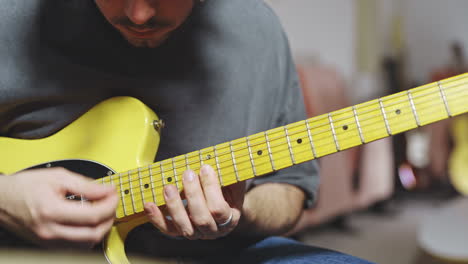 Nahaufnahme-Eines-Erfahrenen-Musikers,-Der-Im-Studio-Eine-Gelbe-Stratocaster-Gitarre-Spielt
